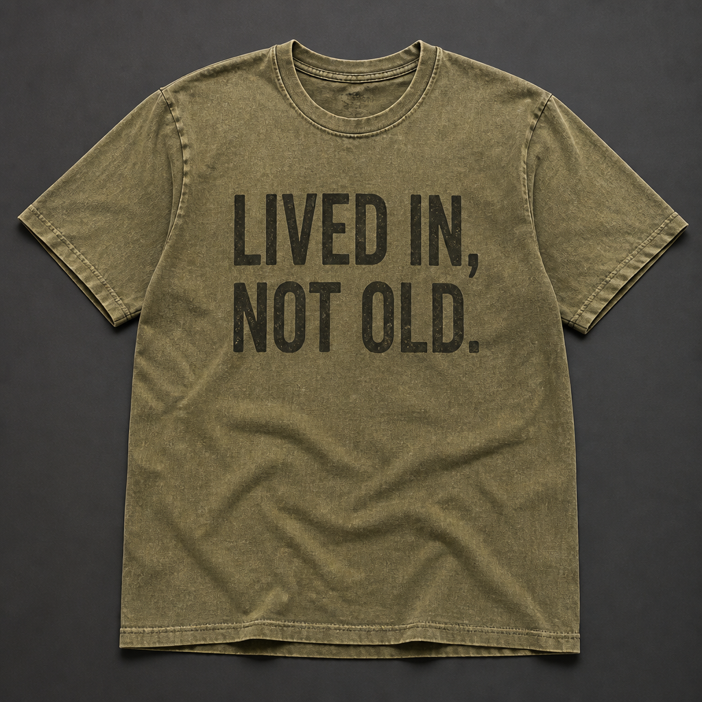 Front of washed olive t-shirt reading LIVED IN, NOT OLD